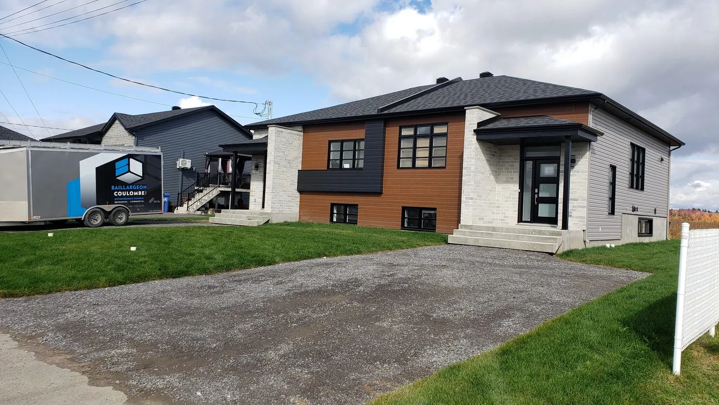 Duplex côte à côte terminé à Notre-Dame-de-Lourdes, vu de face avec sa pelouse et son entrée