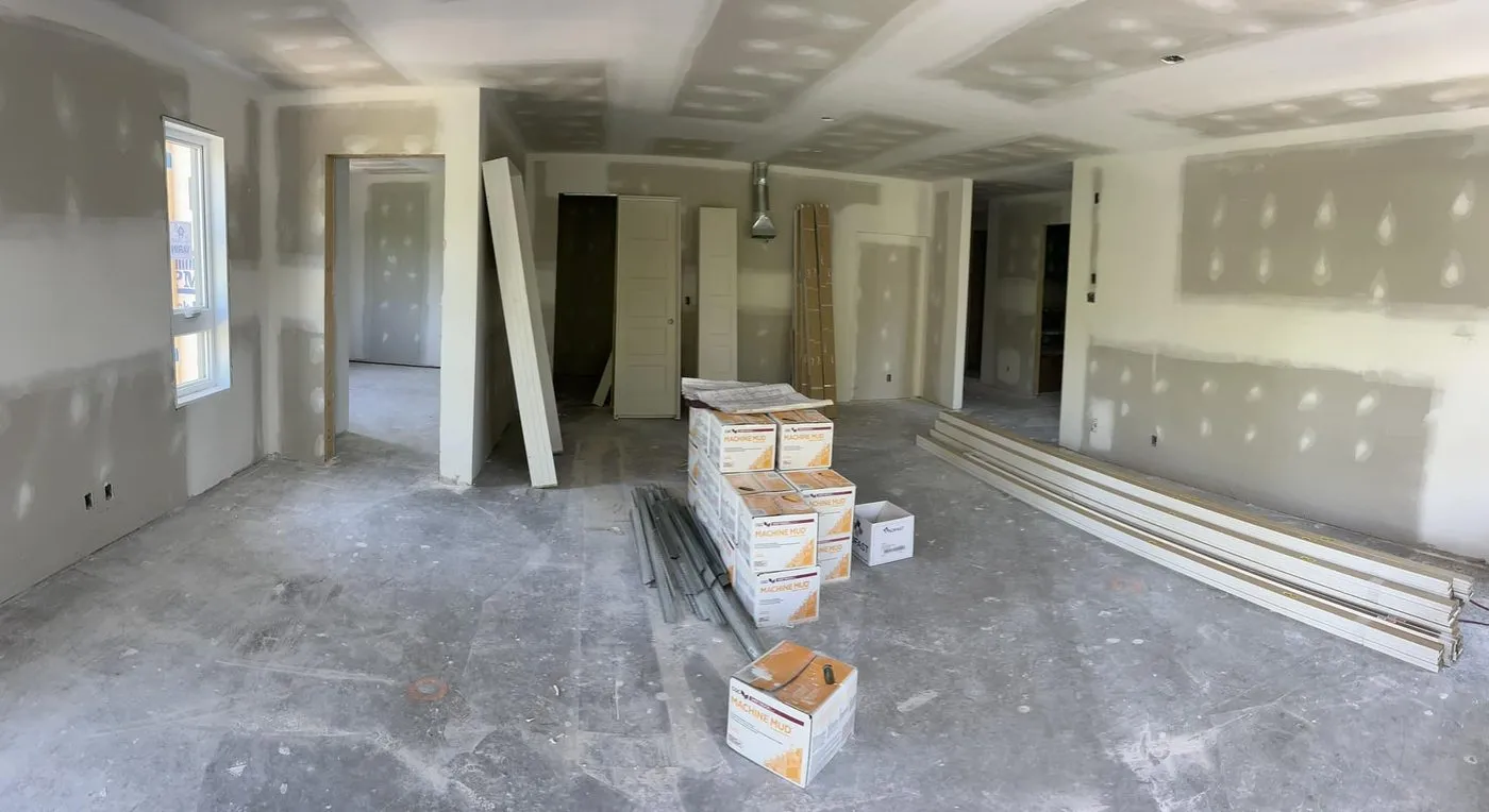 Logement en chantier après la pose du gypse, joints tirés, matériaux de finition en attente sur la dalle