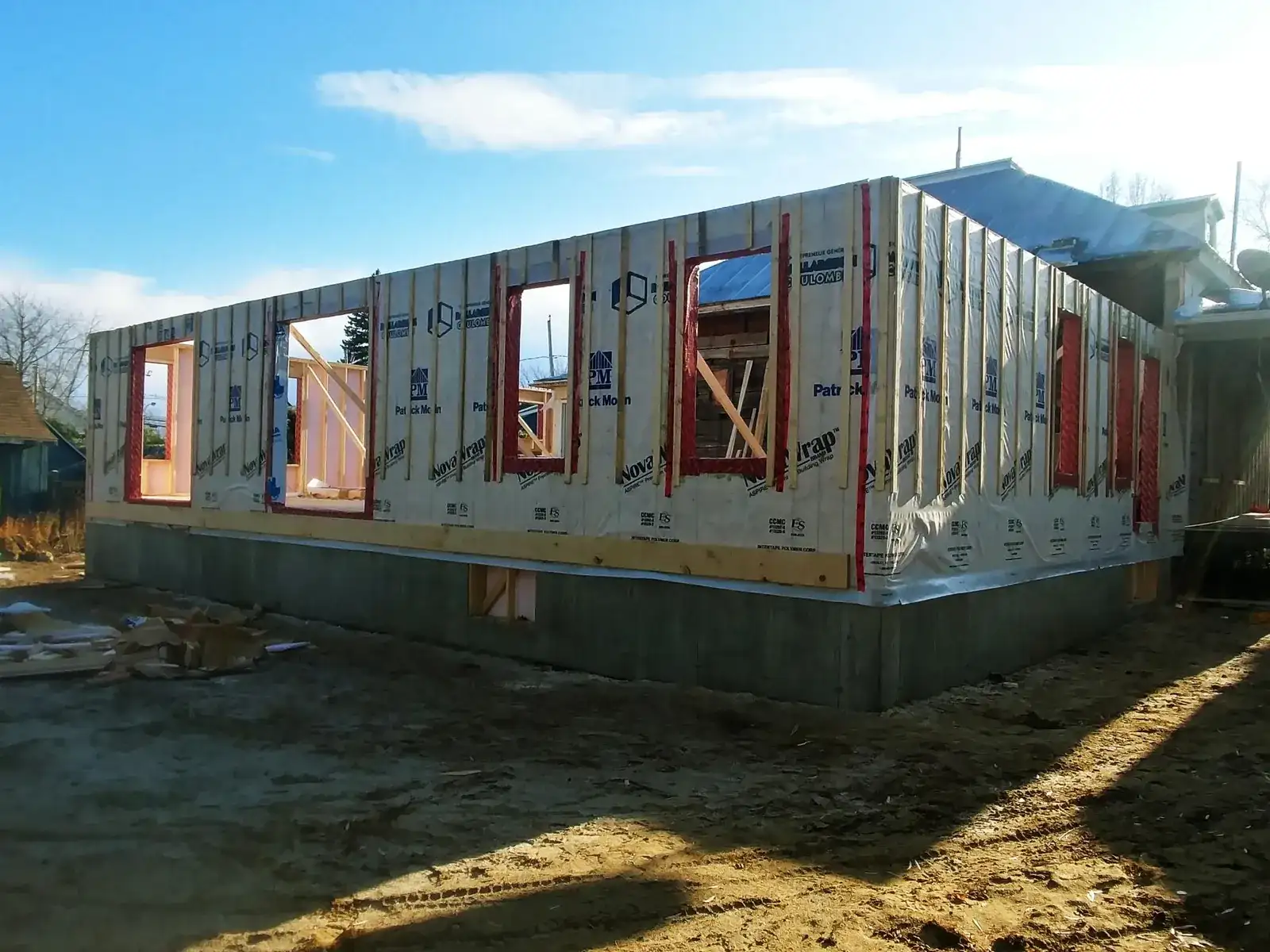 Extension de plain-pied en ossature sur fondation neuve, raccordée à une maison existante, pendant le chantier