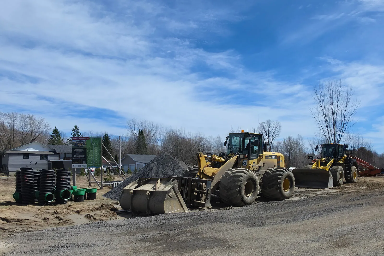 Chargeuses sur pneus et infrastructures de drainage en cours d’installation sur la nouvelle rue de viabilisation au Chemin 15