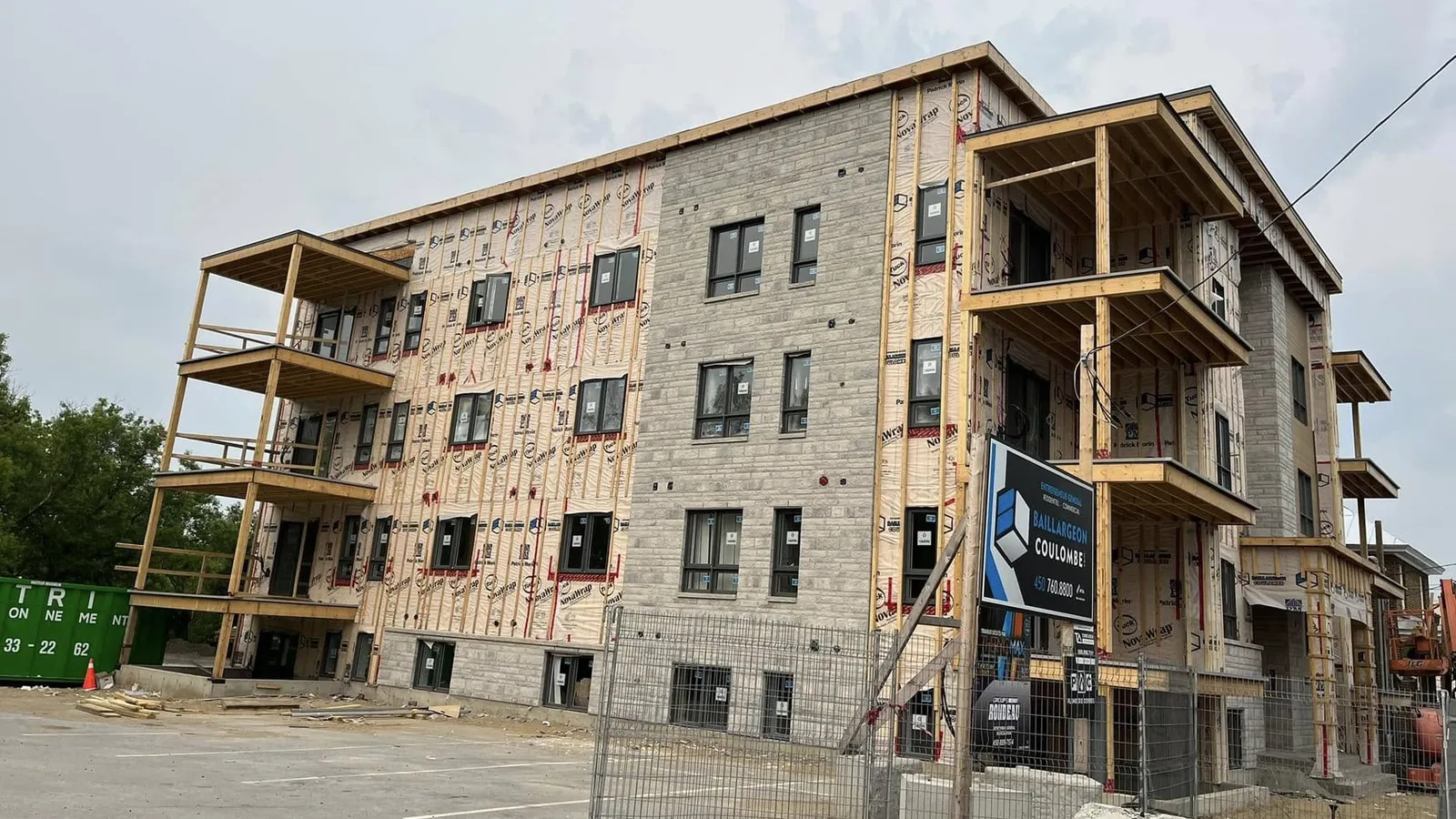 Immeuble de trois étages en chantier, structures de balcons en bois montées à chaque étage