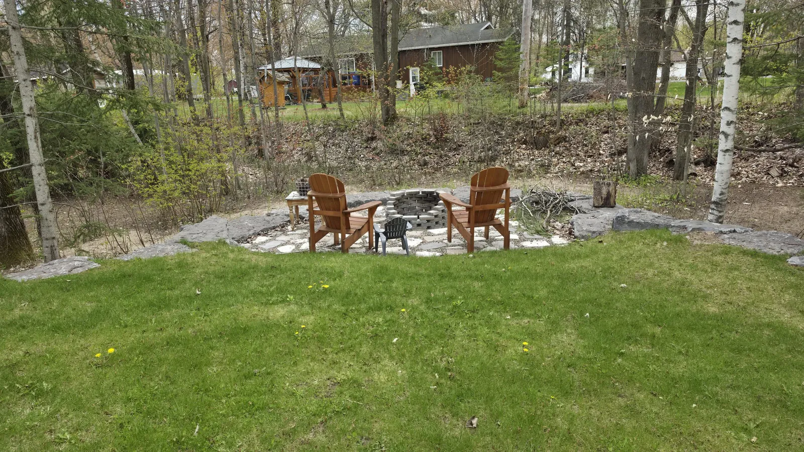 Foyer extérieur et chaises Adirondack aménagés à l’arrière du terrain