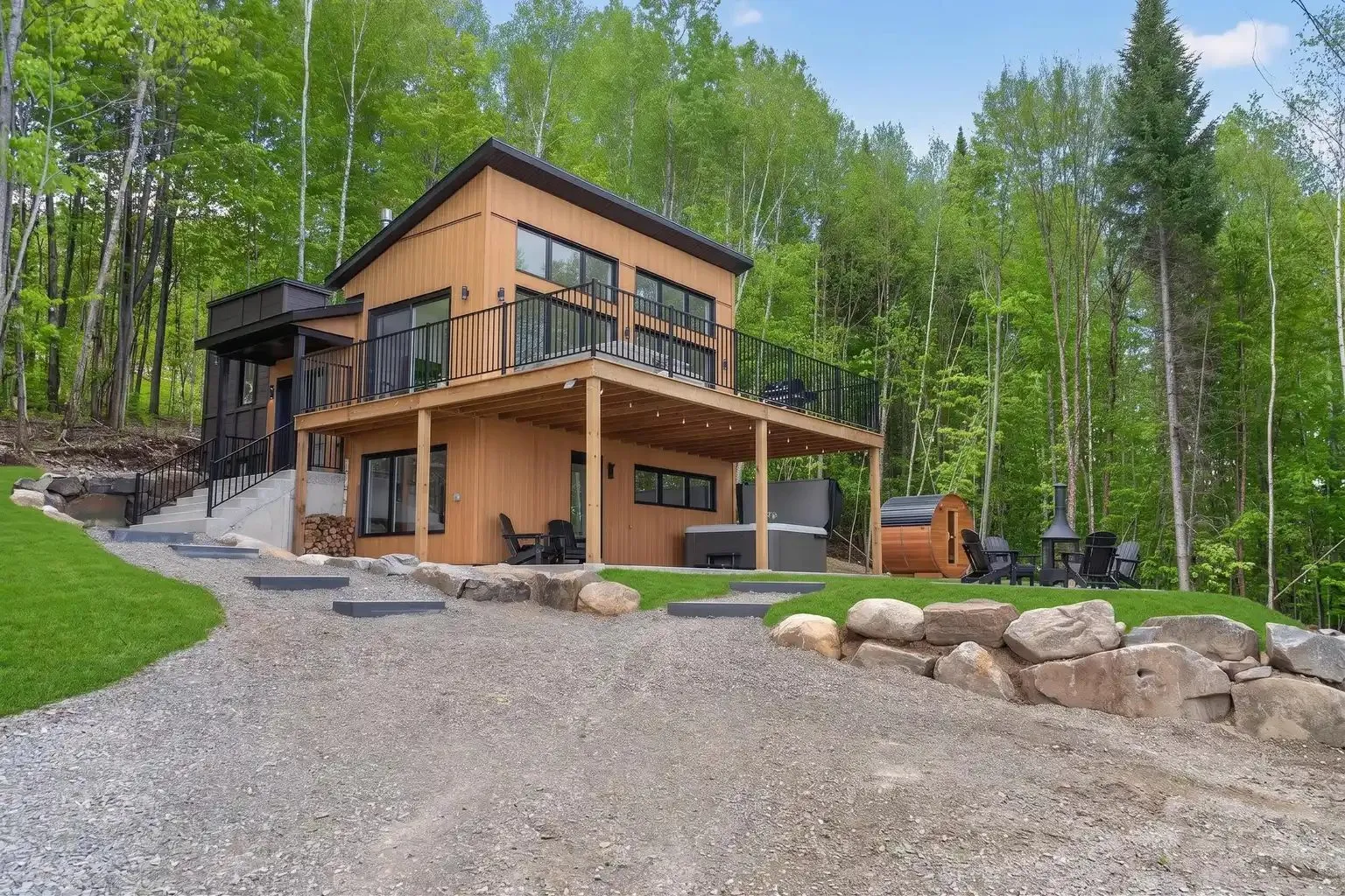 Le chalet vu depuis l'allée de gravier, terrasse couverte au niveau jardin